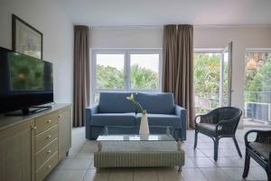 sala de estar con sofá azul y TV en Front Lake 2 Bardolino en Bardolino