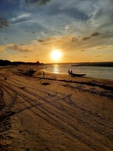 um grupo de pessoas em uma praia ao pôr do sol em Vila das Águas em Atins
