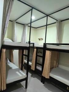 eine Gruppe von 4 Etagenbetten in einem Zimmer in der Unterkunft CheRi Backpackers Hostel in Moalboal