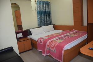 Dormitorio pequeño con cama y espejo en Starline Hotel, en Agartala