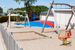 einen Spielplatz mit Rutsche und Schaukel in der Unterkunft Apartment an der Flensburger Förde in Munkbrarup