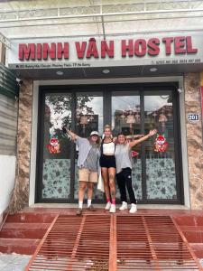três pessoas em pé em frente a uma minivan hostel em Minh Vân Hostel em Ha Giang