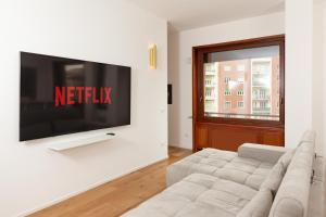 a living room with a couch and a tv on a wall at FREE Parking - 5 Star - Sauna Luxury Apartment in Milan