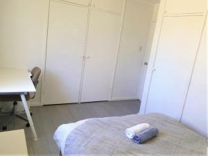 坎培拉的住宿－Private Room in a Shared House-Close to City & ANU-4，一间设有白色橱柜、一张床和一张书桌的房间