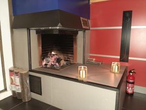 una cocina con chimenea con velas en la encimera en Cottage-4p-Les Hauts de bruyère-293, en Chaumont-sur-Tharonne