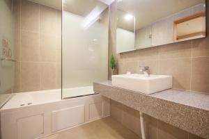 a bathroom with a white sink and a bath tub at Maruo Hotel in Naju