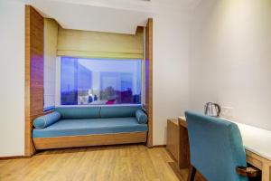 a room with a blue couch and a window at Collection O 78675 Collection O Key Rooms in New Delhi