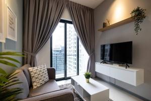 un soggiorno con divano, TV e ampia finestra di NEW! Cozy & Warm Scandinavian Suites walk to LRT a Kuala Lumpur