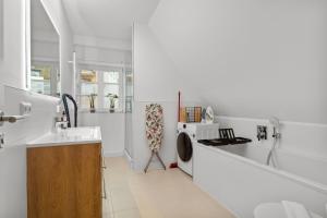 a white bathroom with a sink and a washing machine at Traumhaft gelegene Altbau-Wohnung im Herzen von Weinheim in Weinheim