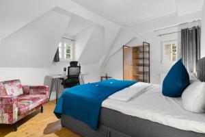 a bedroom with a bed and a chair and a desk at Traumhaft gelegene Altbau-Wohnung im Herzen von Weinheim in Weinheim