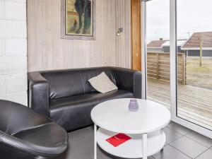 a living room with a leather couch and a table at 6 person holiday home in Thisted in Nørre Vorupør