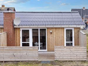 Nørre Vorupørにある6 person holiday home in Thistedの木製のデッキとレンガ造りの家