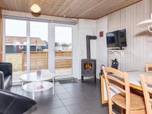 a living room with a table and a stove at 6 person holiday home in Thisted in Nørre Vorupør