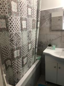 a bathroom with a shower curtain and a sink at Bagoli ház in Bakonybél