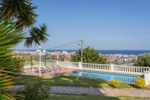 una piscina con sedie e l'oceano sullo sfondo di Hauzify I Villa Formentor a Santa Susanna