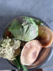 un bol de légumes et de brocolis sur une table dans l'établissement HarroBarro Farms, à Lamjung