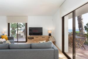 un soggiorno con divano e TV di Hauzify I Villa Formentor a Santa Susanna