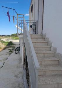 una rampa di scale accanto a un edificio bianco di Casa Francesco a Castellammare del Golfo