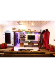 a living room with a couch and a flat screen tv at Sriniketana Homestay in Madikeri