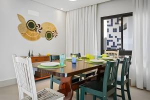a dining room with a table and chairs at bwelcome - pé na areia com piscina GH in Bertioga