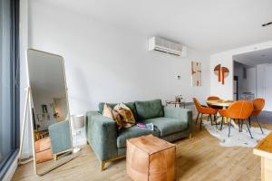 a living room with a couch and a table at The Sweet Escape - Chic Apartment with Rooftop Pool in Melbourne