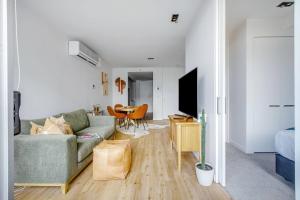 een woonkamer met een bank en een tafel bij The Sweet Escape - Chic Apartment with Rooftop Pool in Melbourne