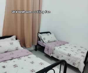 a room with two beds and a chair in it at Umar's Lodge in Bemban