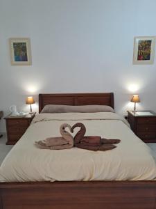 two swans making a heart on a bed at The Misraħ at Rabat in Rabat