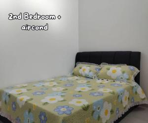Una cama con una colcha con flores. en Umar's Lodge en Bemban