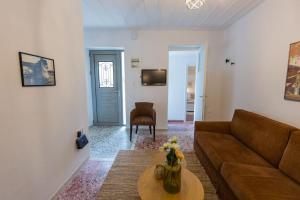uma sala de estar com um sofá e uma mesa em Μονοκατοικία - The Olive Tree em Lepanto