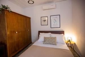 um quarto com uma cama e um armário de madeira em Μονοκατοικία - The Olive Tree em Lepanto