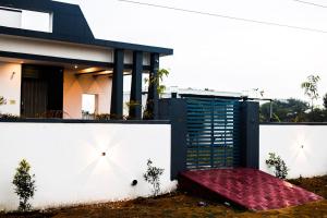 een huis met een wit hek en een rood tapijt bij Luxuria Farmstays in Jaipur