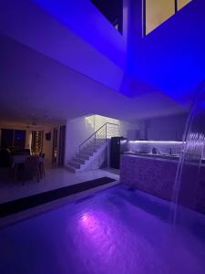 a room with a swimming pool with a blue lighting at Casa privada con piscina Villa Encanto in Carmen de Apicalá