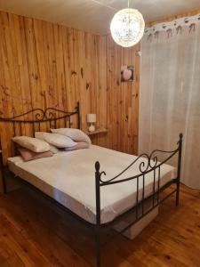 a bedroom with a bed with a wooden wall at La Pause Aigoual in Valleraugue