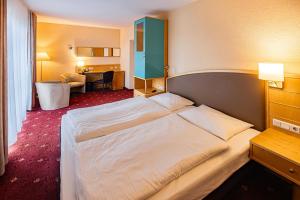 a hotel room with a large bed and a desk at Ringberg Hotel in Suhl