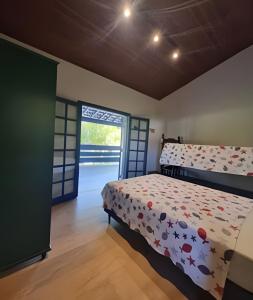 a bedroom with a bed and an open door at bwelcome - casa de praia com estilo único GH in Bertioga +15 photos