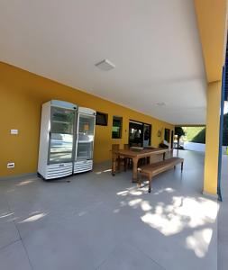 an empty room with a table and a bench at bwelcome - casa de praia com estilo único GH in Bertioga