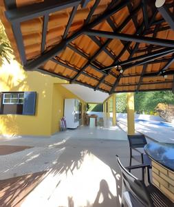 an outdoor patio with a wooden pergola at bwelcome - casa de praia com estilo único GH in Bertioga