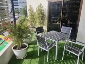 een tafel en stoelen op een balkon met planten bij Harmony Health Hub in Ban Sam Kong