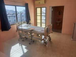 een ziekenhuisbed in een kamer met een raam bij Harmony Health Hub in Ban Sam Kong