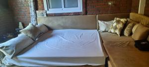 uma cama com lençóis brancos e almofadas em Guesthouse Nut em Luxor
