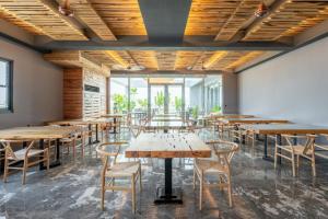 um restaurante com mesas e cadeiras de madeira e janelas em 禾楓覓月文旅 em Minxiong