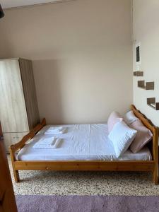 a bedroom with a wooden bed with white sheets and pillows at Grekou Farmhouse in the waves in Áyioi Apóstoloi +40 photos