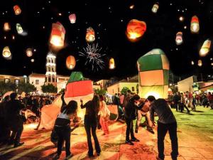 a group of people are flying lanterns at aestival at Grekou Farmhouse in the waves in Áyioi Apóstoloi