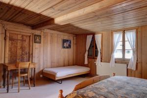 ein Schlafzimmer mit einem Bett und einem Schreibtisch in einem Zimmer in der Unterkunft Chalet Marie-José in Chateau-d'Oex