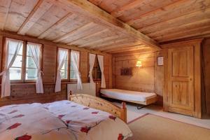 una camera con un letto in una cabina di legno di Chalet Marie-José a Chateau-d'Oex