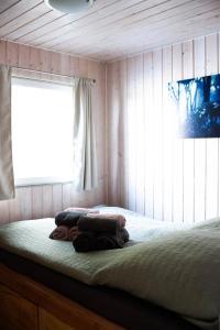 a bed in a room with a window and towels at Hausboot Insel Valentinswerder Berlin in Berlin