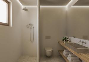 y baño con lavabo y aseo. en AMĀRIA Beach Resort by NOMÉE Hospitality Group en Kamari