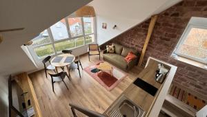 vista sul soffitto di un soggiorno con divano e tavolo di Le Pommier - Appt avec jardin partagé a Puberg