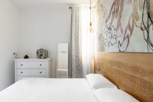 sypialnia z łóżkiem i komodą z obrazem w obiekcie Saffi Glamorous Apartment by Wonderful Italy w Bolonii
